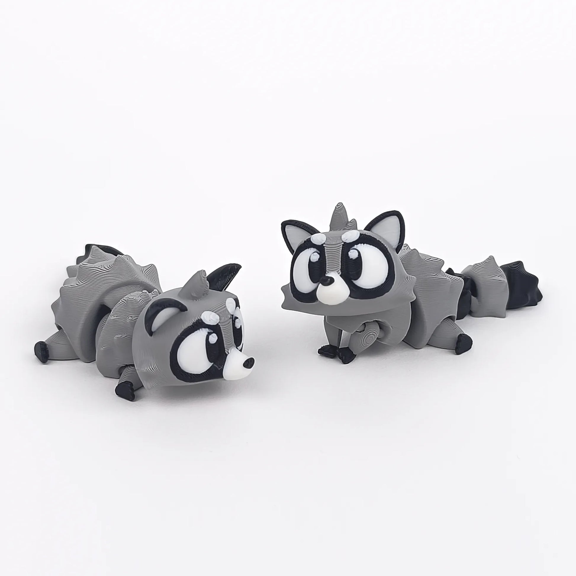 Miniature Flexi Raccoon figure by Tattles Told 3D, featuring detailed design and flexible body for playful display.