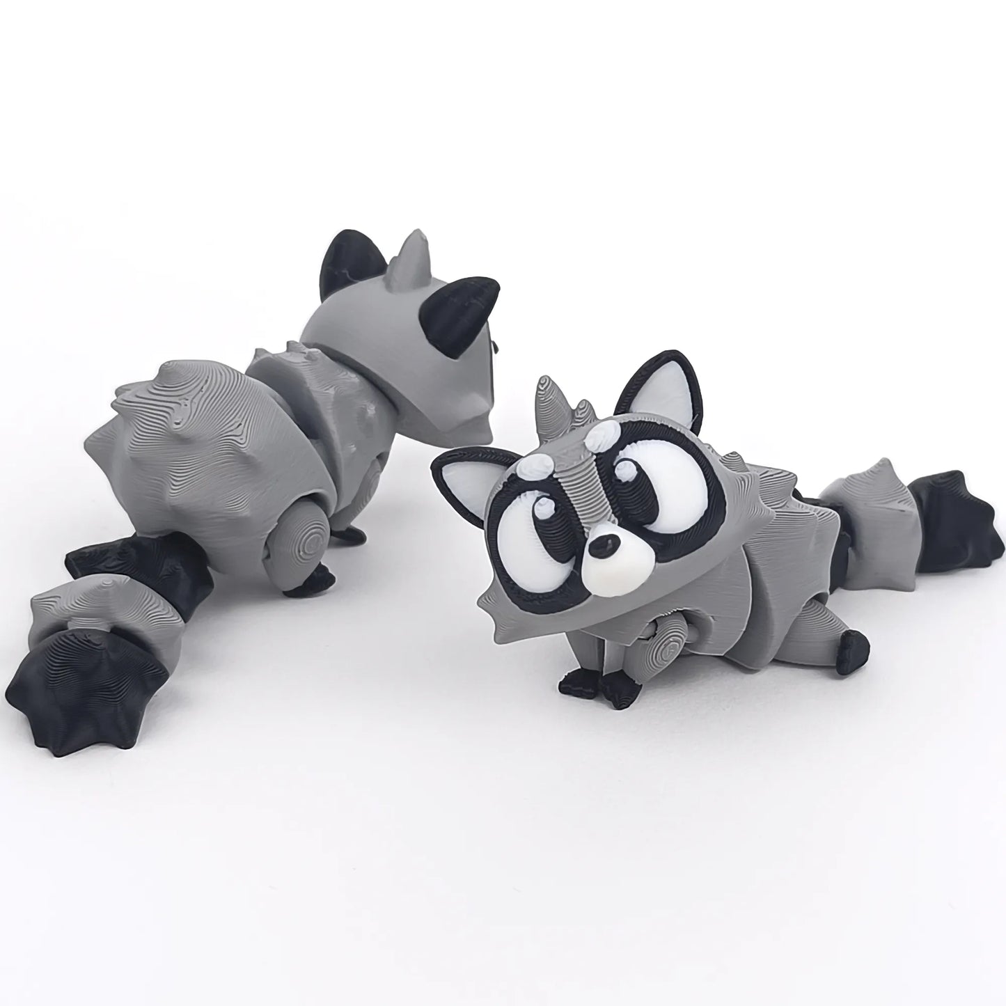 Miniature Flexi Raccoon figure by Tattles Told 3D, colorful and detailed 3D-printed raccoon sculpture.