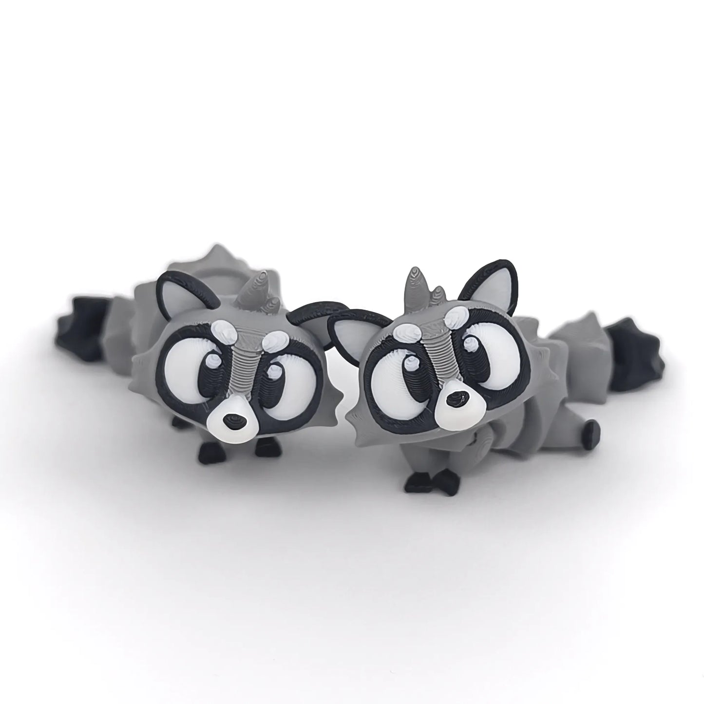 Miniature Flexi Raccoon figurine by Tattles Told 3D, showcasing a detailed, flexible raccoon sculpture in a playful pose.