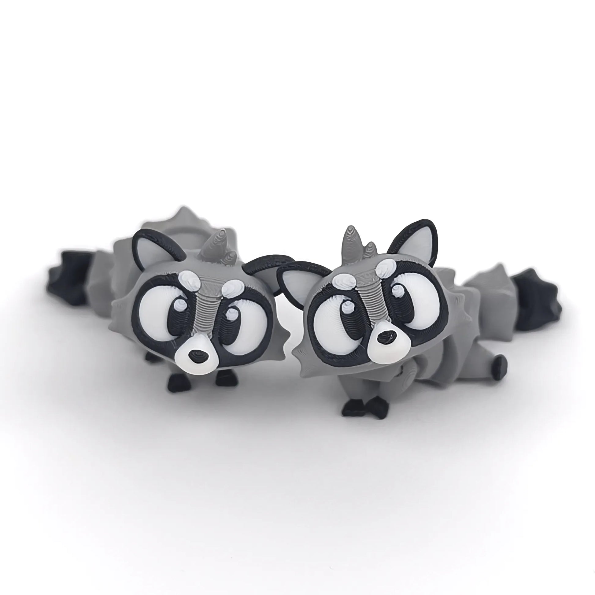 Miniature Flexi Raccoon figurine by Tattles Told 3D, showcasing a detailed, flexible raccoon sculpture in a playful pose.