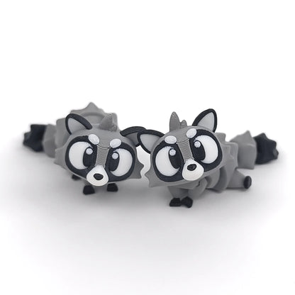 Miniature Flexi Raccoon figurine by Tattles Told 3D, showcasing a detailed, flexible raccoon sculpture in a playful pose.