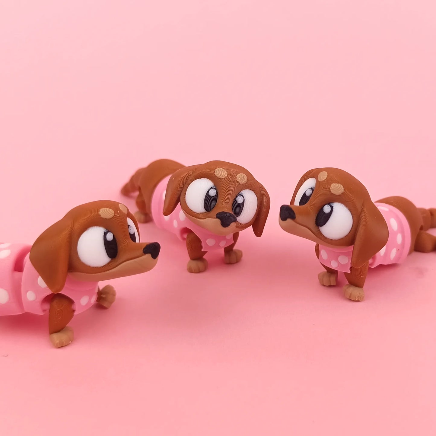 Miniature Flexi Sausage Dog figurine by Tattles Told 3D, showing detailed flexible sausage dog sculpture on a white background.